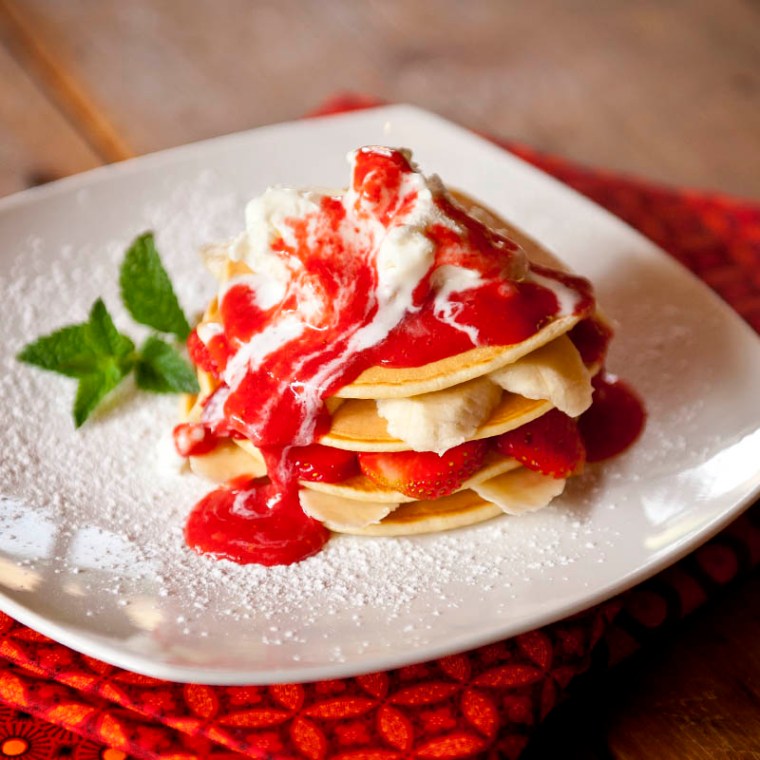 A stack of American style pancakes with bananas and strawberries, topped with a generous helping of ice-cream and drizzled with liquidised strawberries - so fresh and fruity, it almost feels healthy! (© All Rights Reserved)